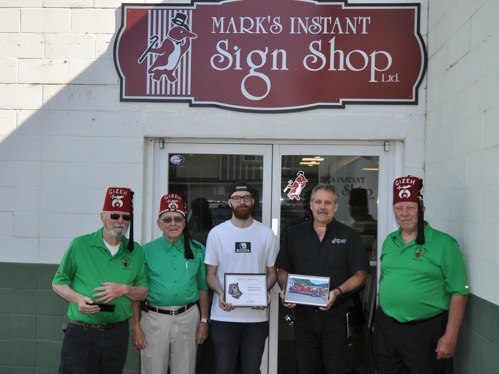 Cowichan valley Shrine Club members Monte Engelson, Brian Nicol and Pat Ffyfe present Certificate of Appreciation to the owners of Mark's Instant Sign Shop, Duncan, B.C. on 26 July 2017 (photo by Cowichan Valley Shrine Club)