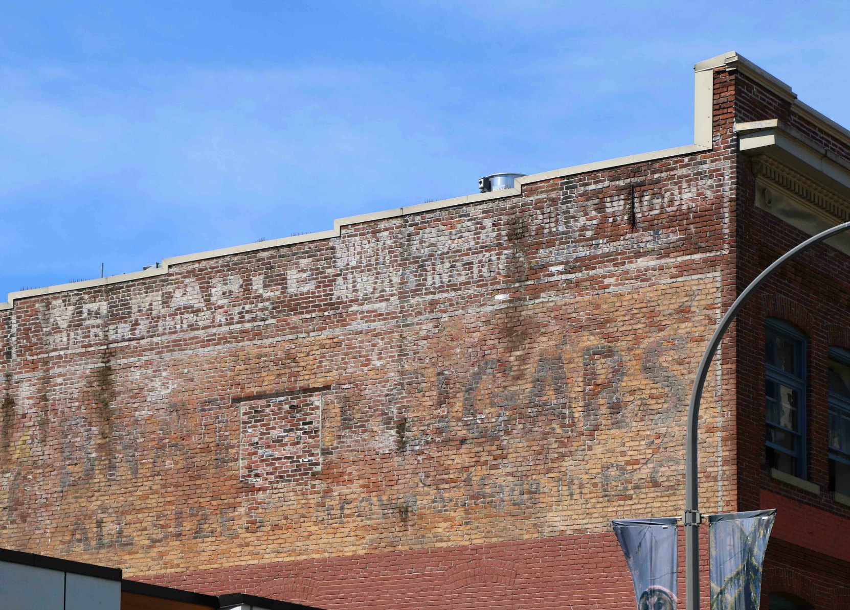 Signs for William Mable's carriage making business are still visible on the east wall of 713-715 Johnson Street, Victoria, B.C. ,built in 1908 by architects Thomas Hooper and C. Elwood Watkins for carriage maker William James Mable, a member of Victoria-Columbia Lodge No.1 (photo by Temple Lodge No. 33 Historian)